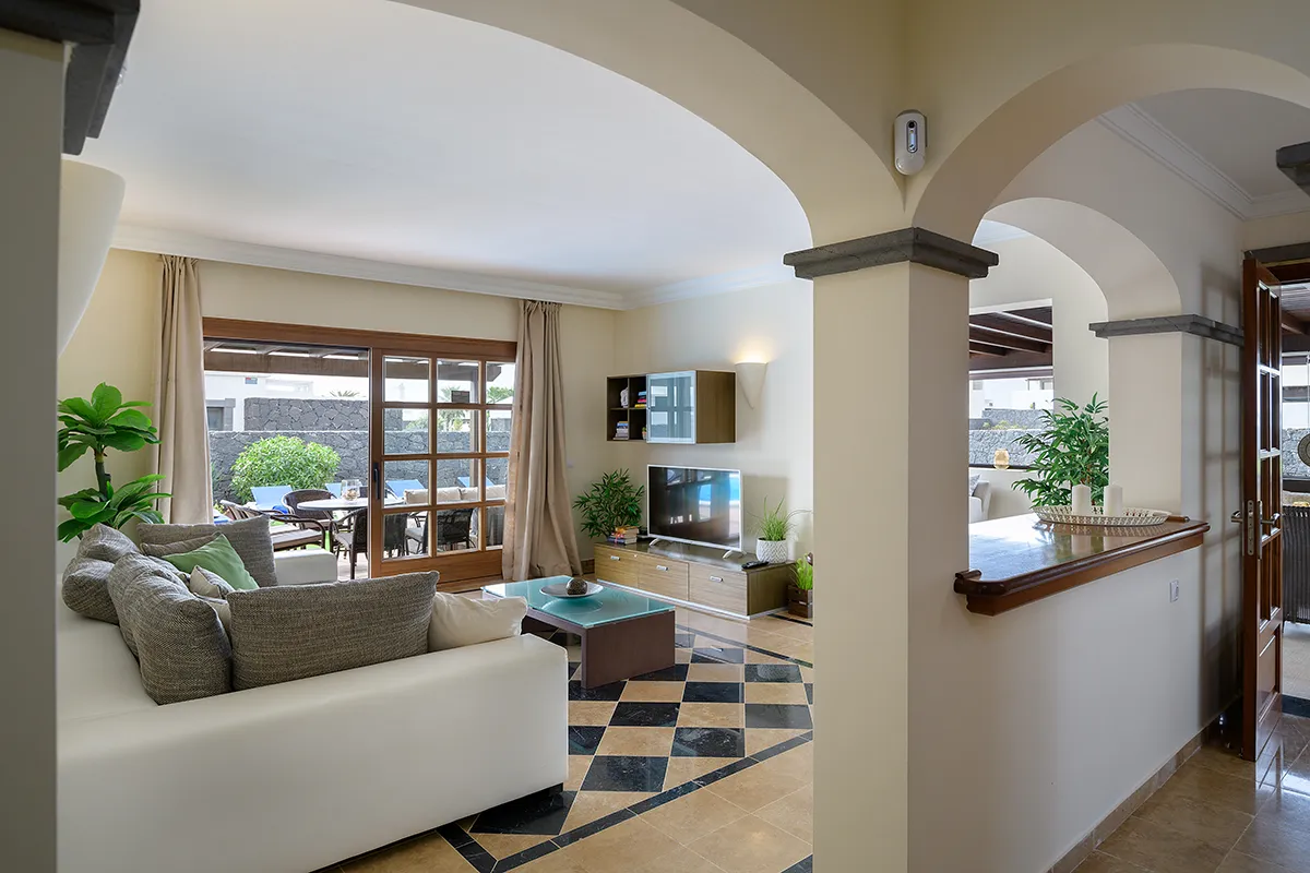 Zugang zum Wohnzimmer mit Sofa und Fernseher in Hipoclub Villa Aguamarina 27