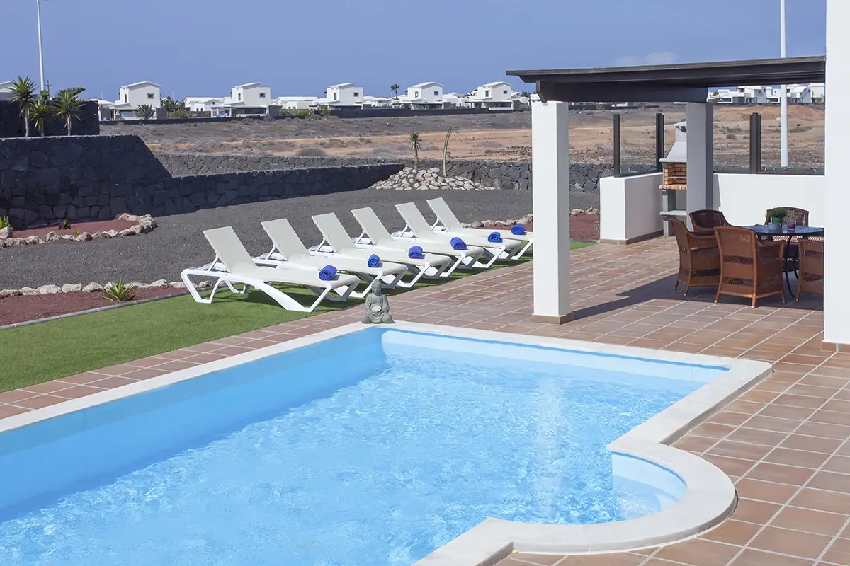 Piscina con hamacas dispuestas en zona de solárium en Hipoclub Villa Aguamarina 4