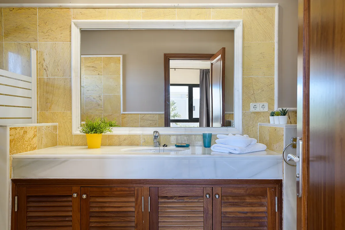 Cuarto de baño completamente equipado con ducha, lavabo y mobiliario funcional, Hipoclub Villa Aguamarina 5