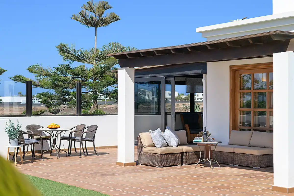 Vista de la terraza cubierta y zona exterior amuebladas con comedor y sofás, Hipoclub Villa Aguamarina 5