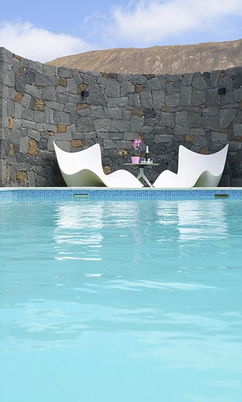 Piscina de Villa Alisios Piscina con zona descanso y muro volcánico decorativo en Villa Alisios 43 Hipoclub