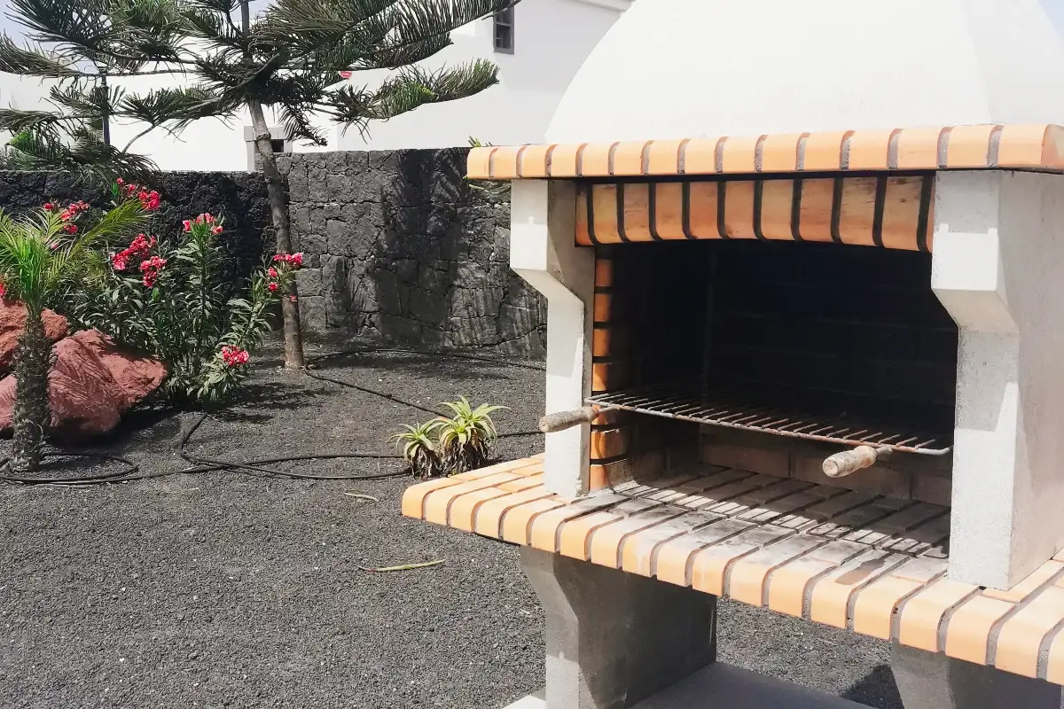 Barbacoa situada en zona ajardinada para uso exterior en Hipotel Villa Aguamarina 14