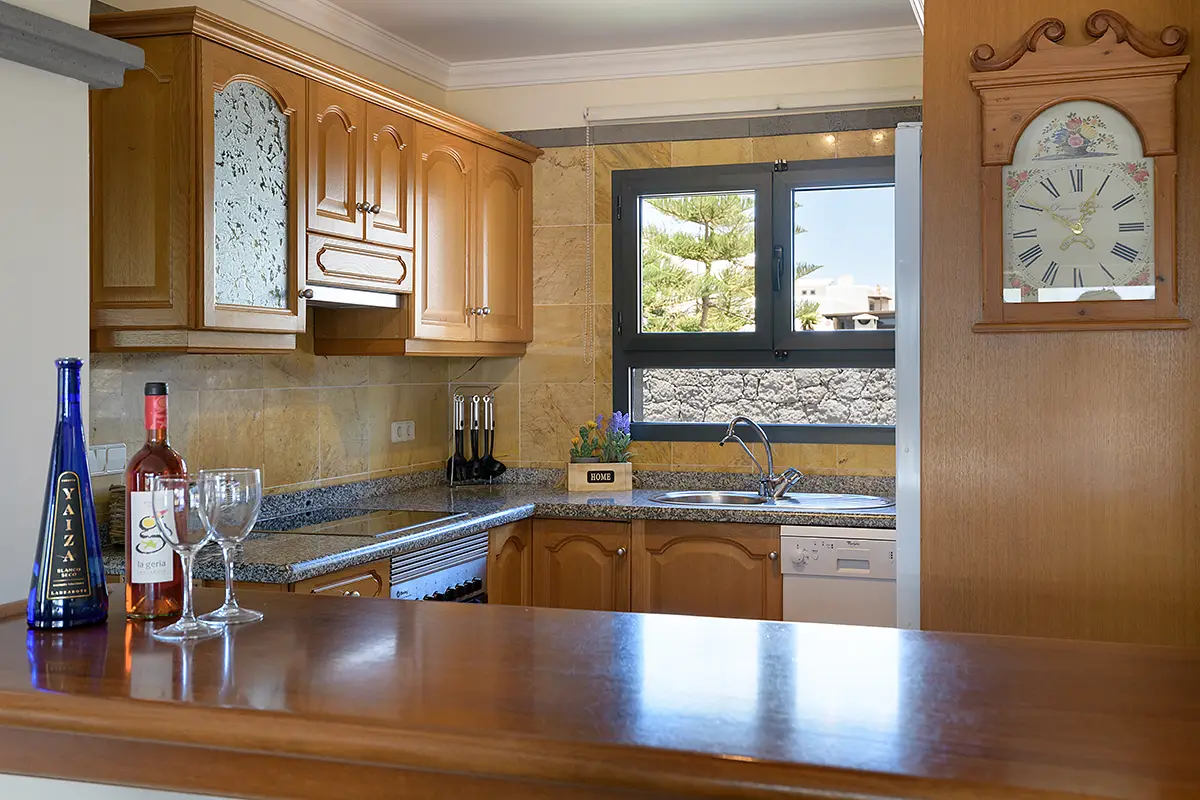 Cocina conectada al salón mediante ventana office en Hipoclub Villa Aguamarina 11