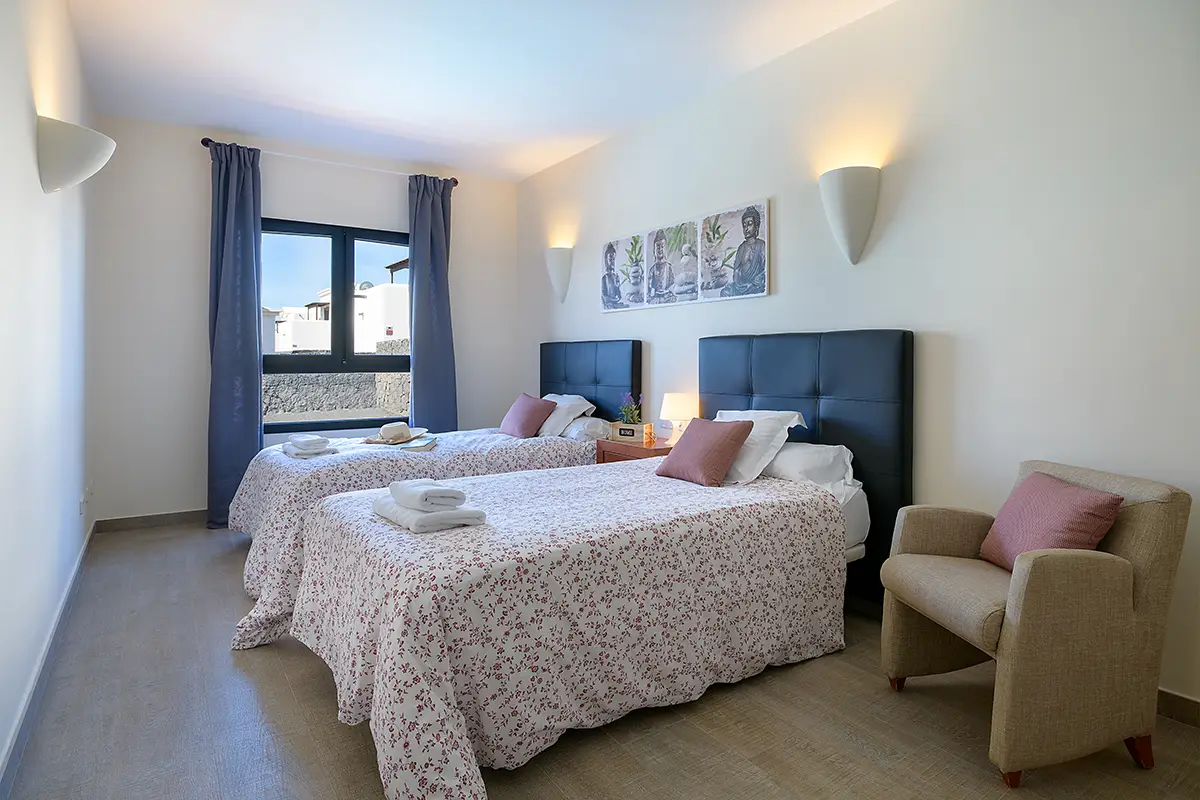 Habitación doble con camas individuales y orientación hacia el jardín exterior en Hipoclub Villa Aguamarina 30