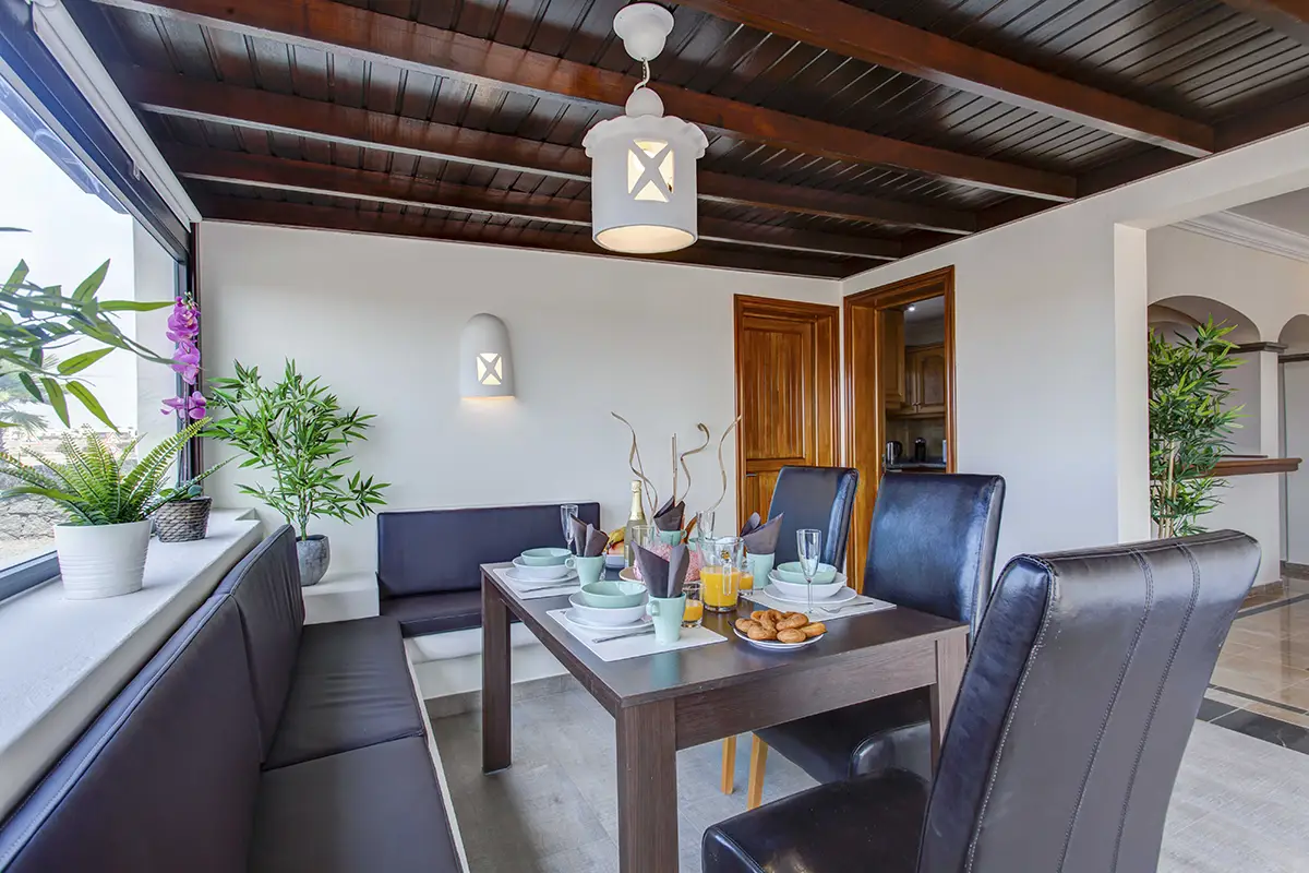 Comedor interior con banco bajo ventana lateral en Hipoclub Villa Aguamarina 4