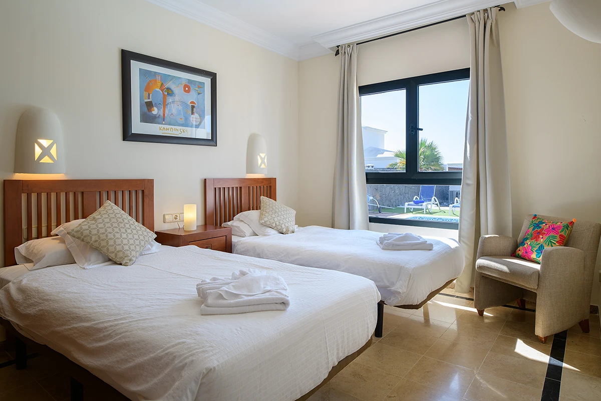 Dormitorio con camas individuales y vistas al jardín, Hipoclub Villa Aguamarina 5