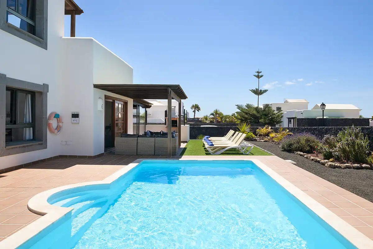 Piscina exterior con zona de hamacas al fondo y porche cubierto adyacente en Hipoclub Villa Aguamarina 30