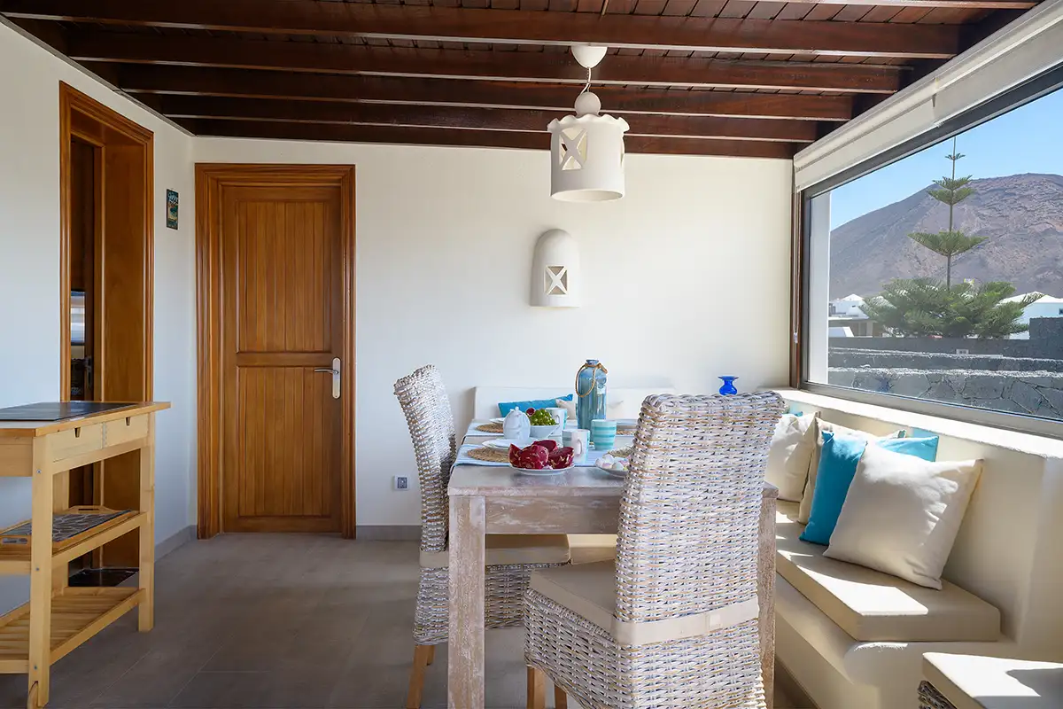 Mesa de comedor junto a un gran ventanal en Hipoclub Villa Aguamarina 32