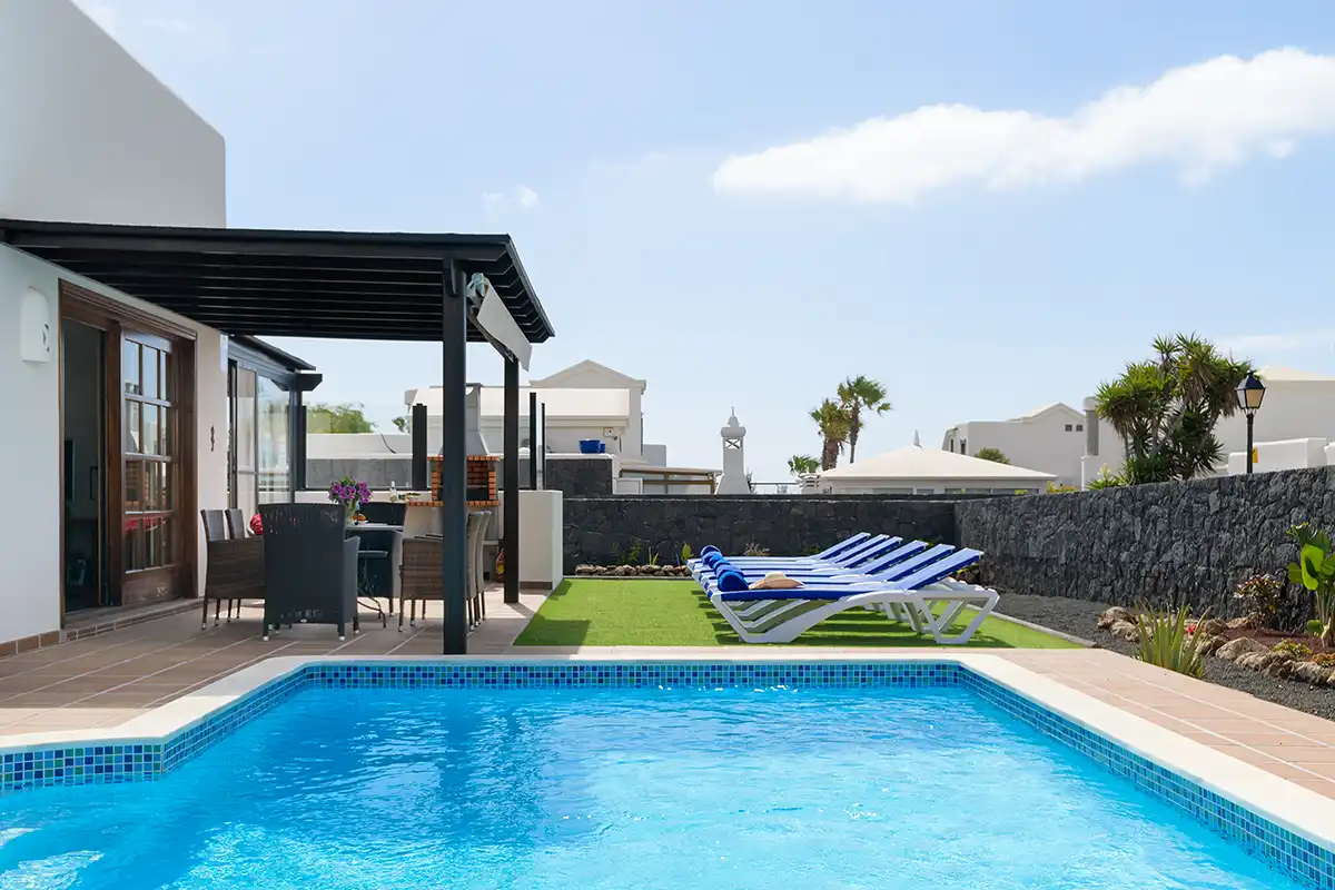 Piscina con terraza cubierta al fondo y hamacas en Hipoclub Villa Aguamarina 32