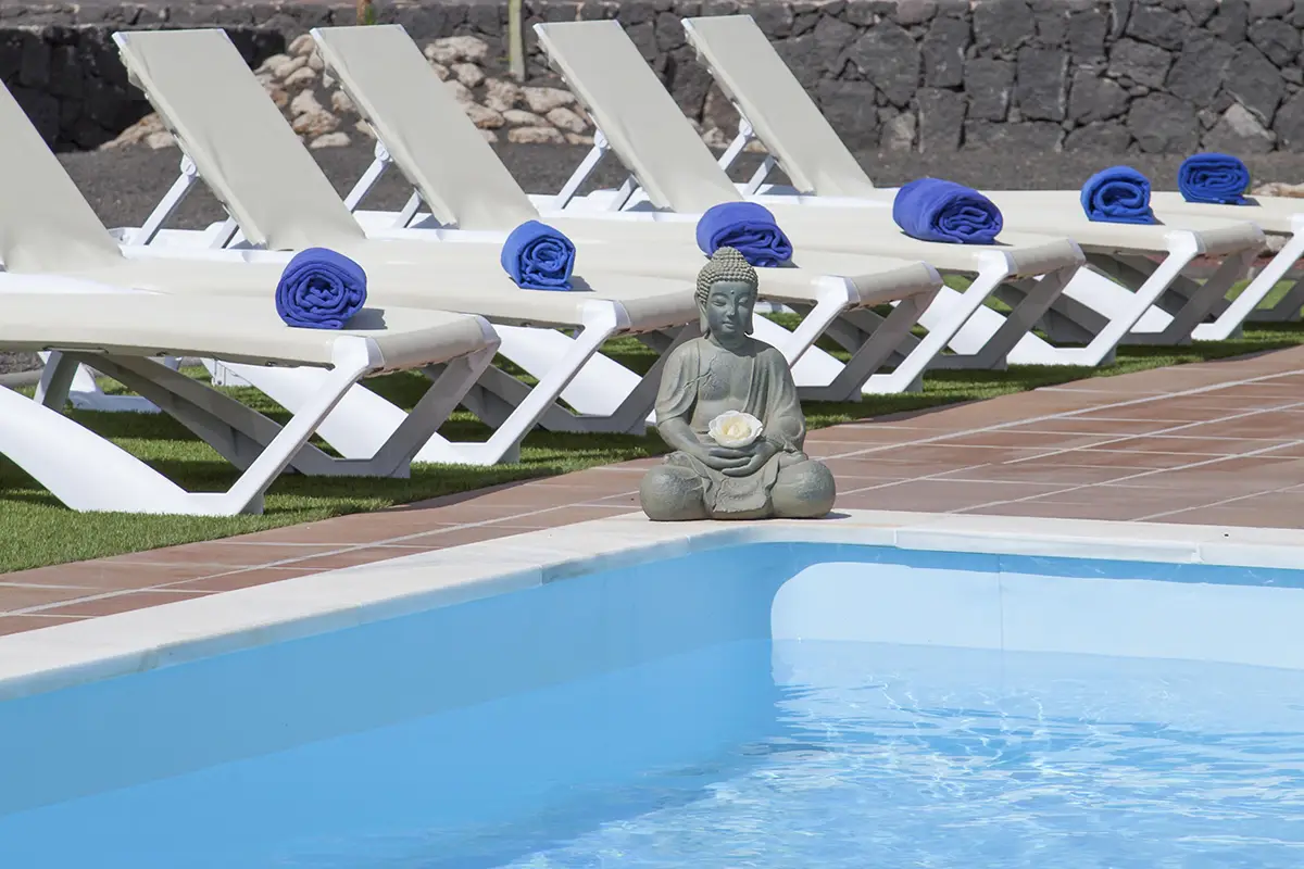 Hamacas y figura decorativa en estilo zen junto a la esquina de la piscina en Hipoclub Villa Aguamarina 4