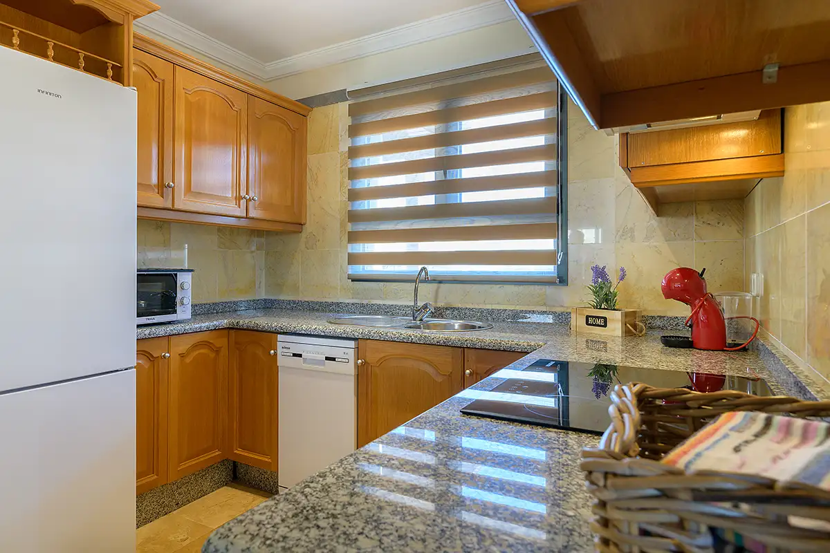 Cocina interior equipada con mobiliario y electrodomésticos visibles en Hipoclub Villa Aguamarina 30