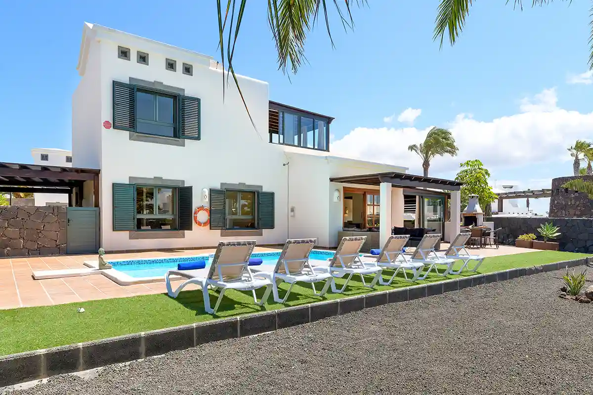 Jardín exterior con presencia de piedra volcánica en Hipoclub Villa Zafiro 54