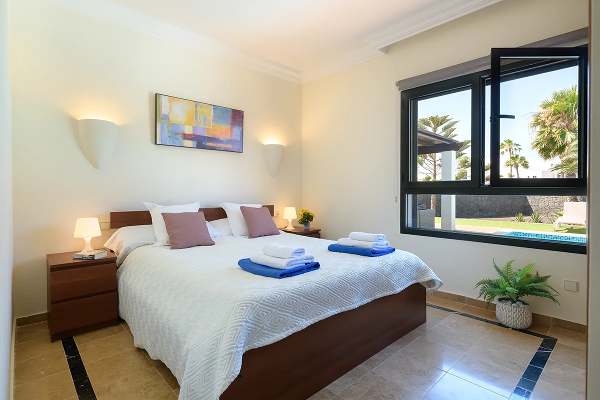 Dormitorio con vistas al jardín exterior en Hipoclub Villa Zafiro 54