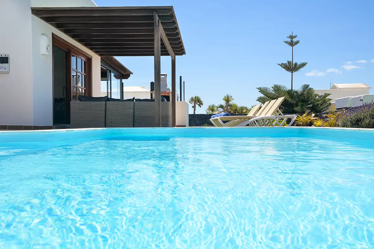 Perspectiva desde el área de piscina hacia la zona de descanso exterior en Hipoclub Villa Aguamarina 30
