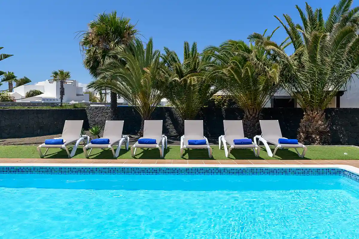 Hamacas para tomar el sol ubicadas frente a la piscina en Hipoclub Villa Zafiro 54