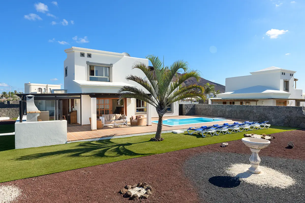 Large garden with palm tree and decorative fountain at Hipoclub Villa Aguamarina 1
