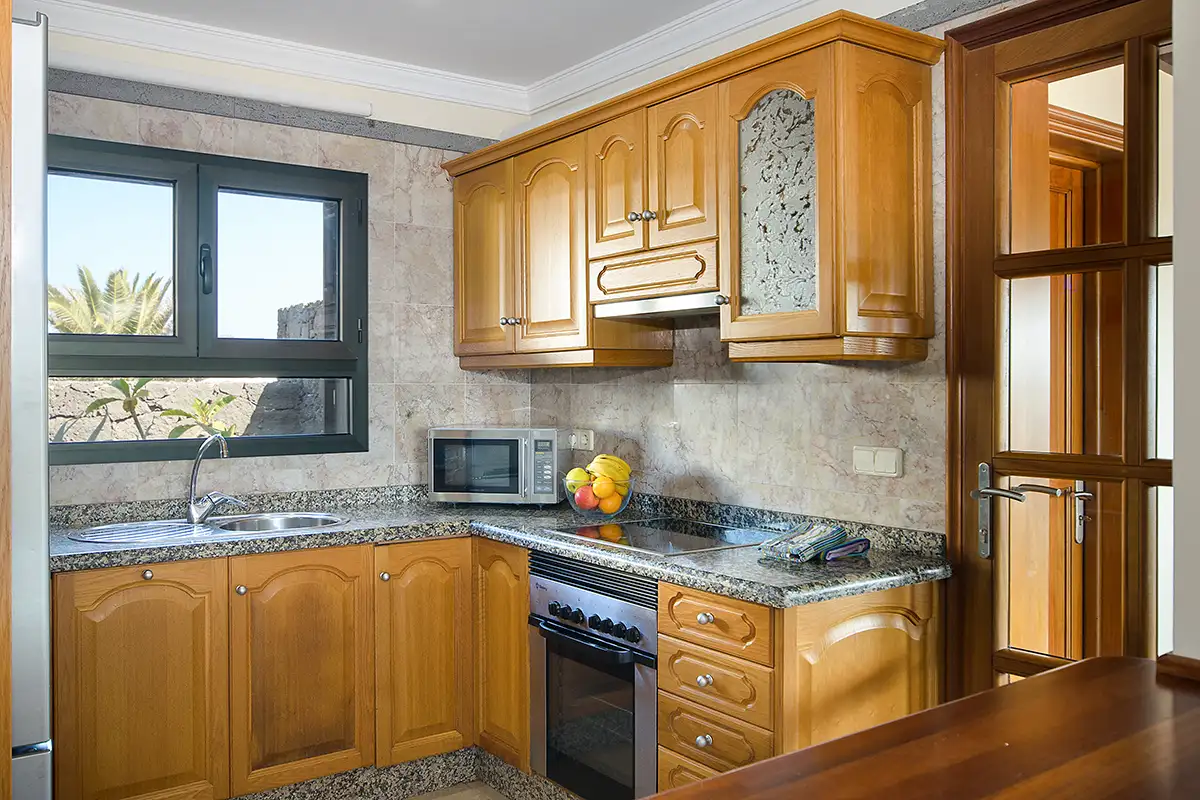Cocina con vitrocerámica y microondas en la Villa Hipoclub
