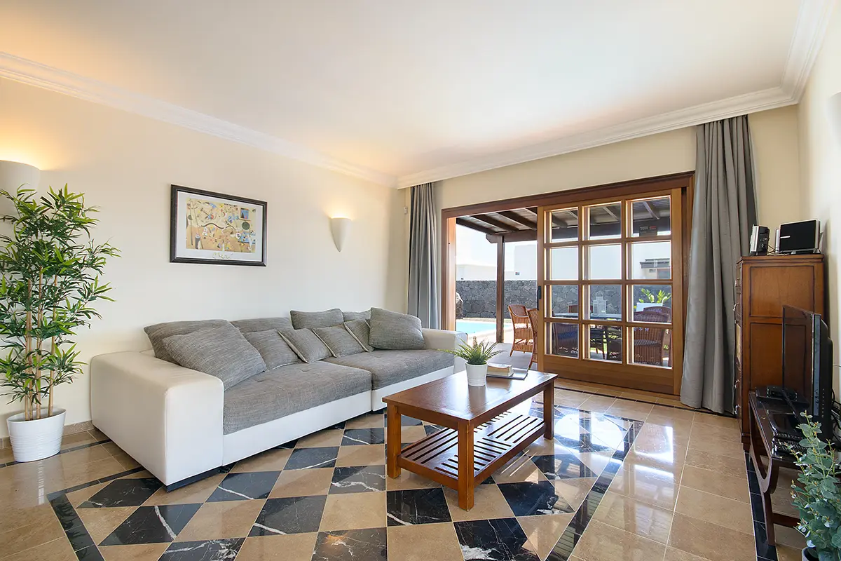 Wohnzimmer mit Sofa und Fernseher in Hipoclub Villa Aguamarina 28
