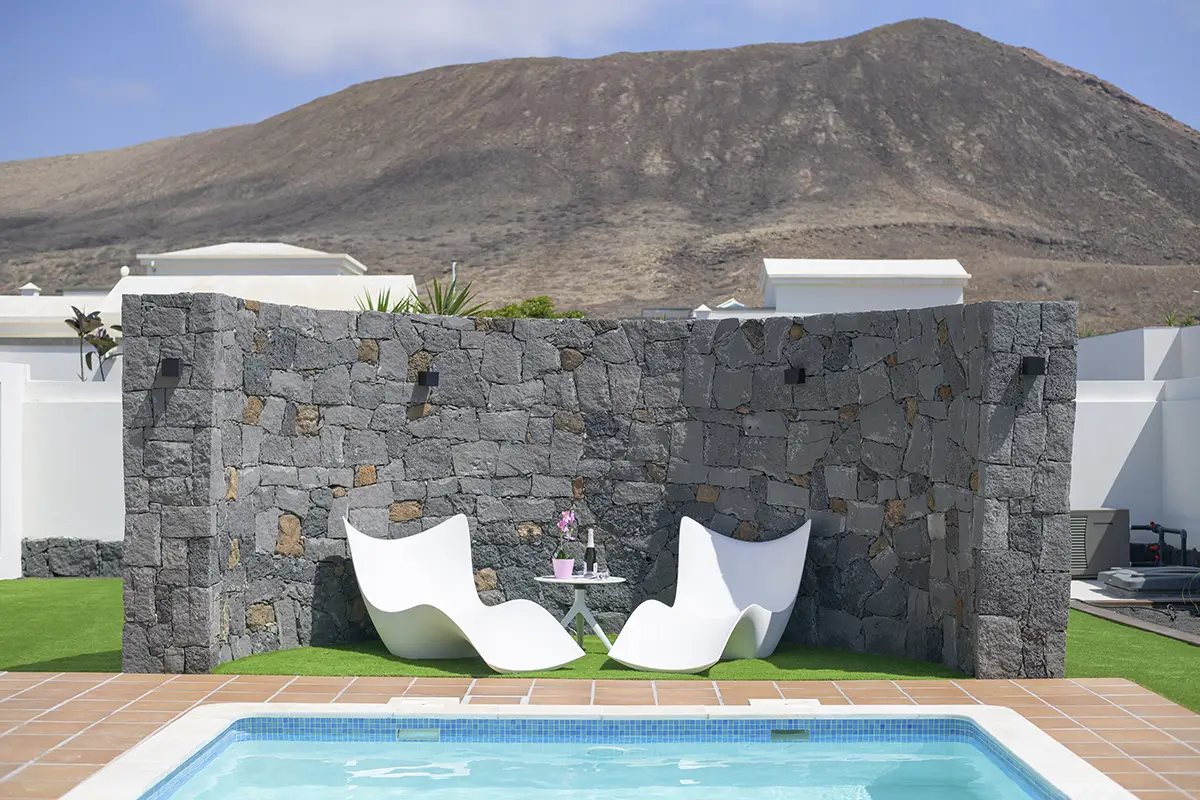 Stilvolle Sitzecke mit Tisch am Pool der Villa Alisios 43 Hipoclub