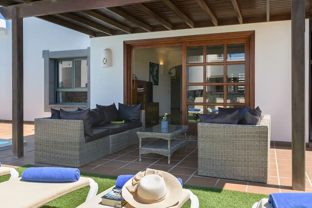 Zona de porche situada bajo pérgola de madera con mobiliario exterior visible en Hipoclub Villa Aguamarina 30