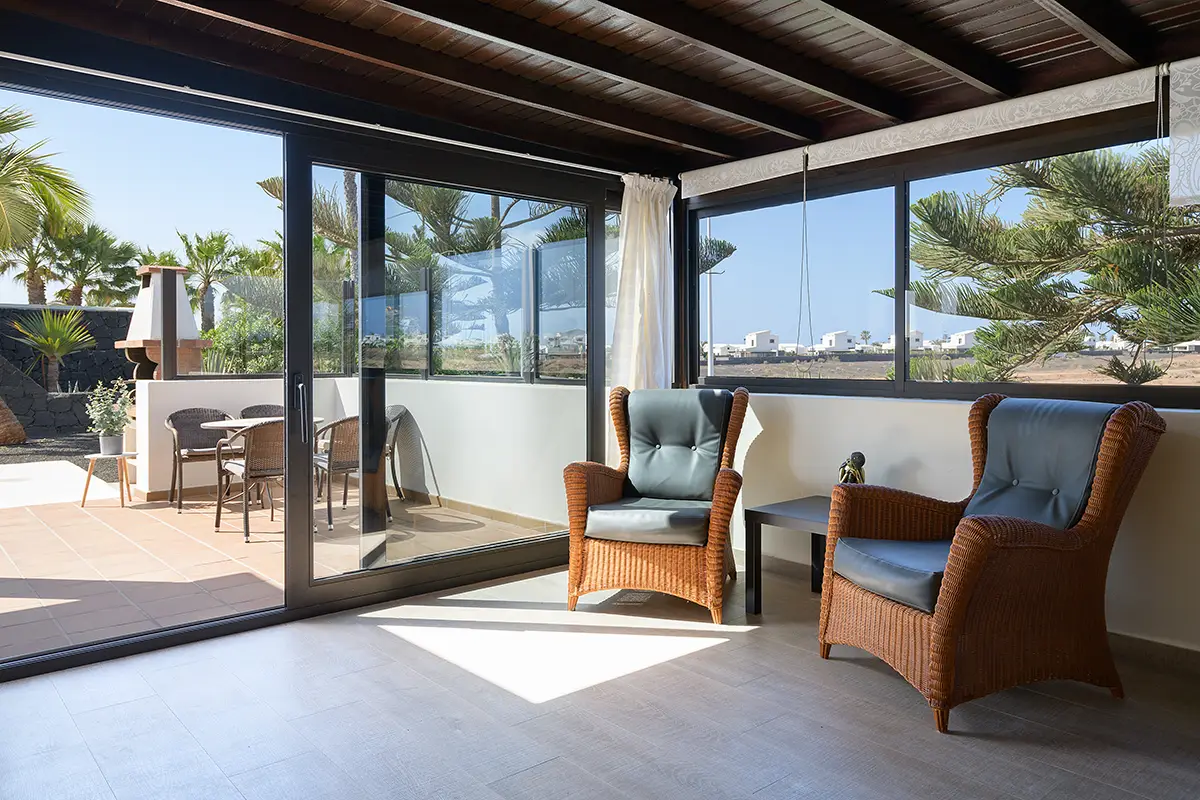 Cómodos sillones de mimbre en el salón acristalado con vistas al exterior, Hipoclub Villa Aguamarina 5