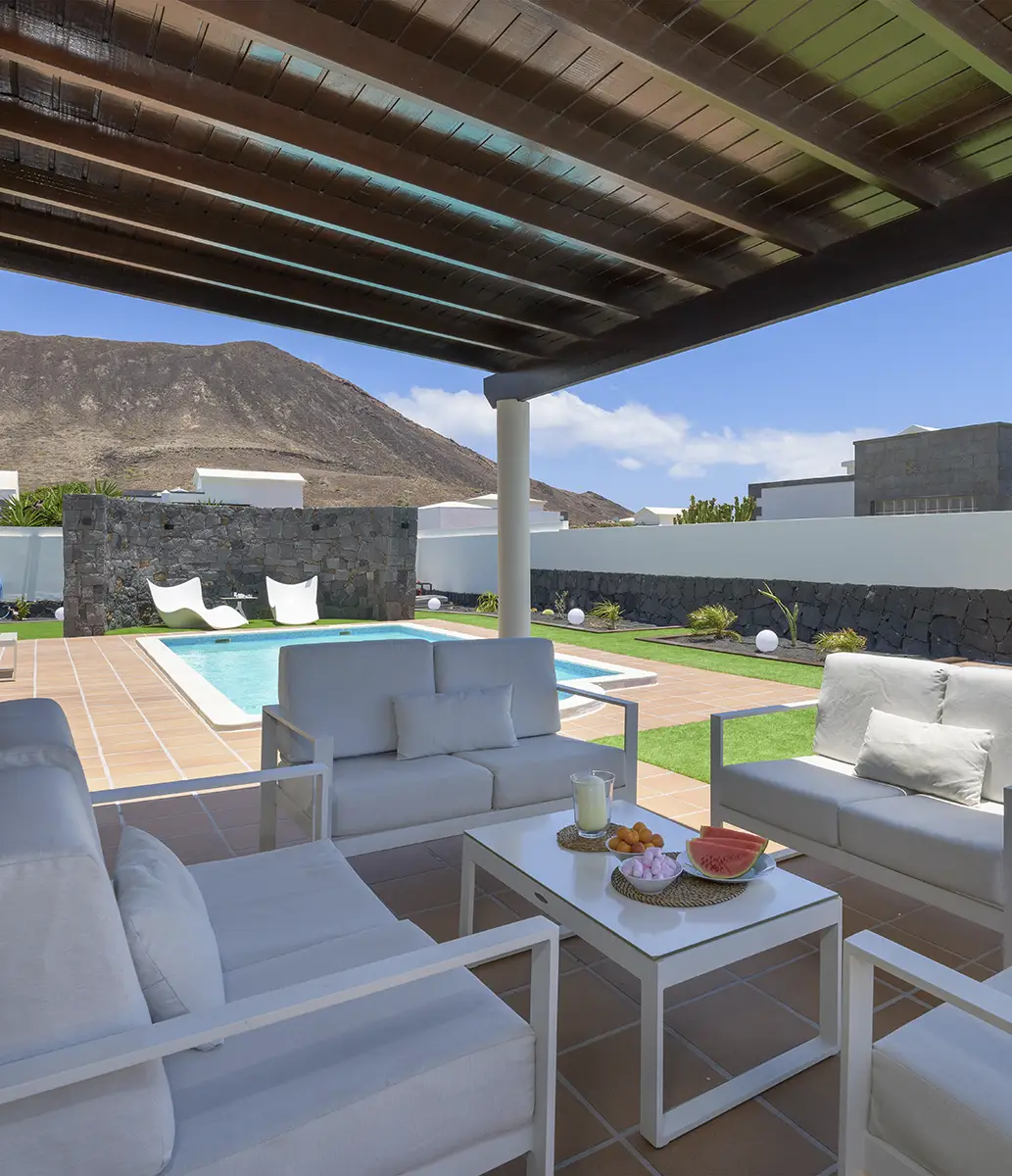 Möblierte Terrasse Möblierte Terrasse mit Sesseln und Blick auf den Pool und den Garten